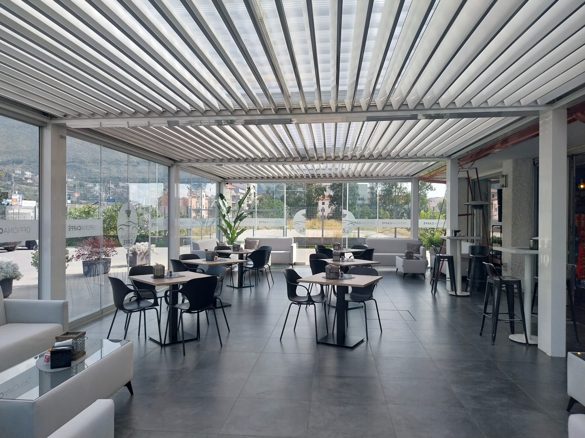 Interno di Officina Caffè con tavoli, sedute e ambiente luminoso
